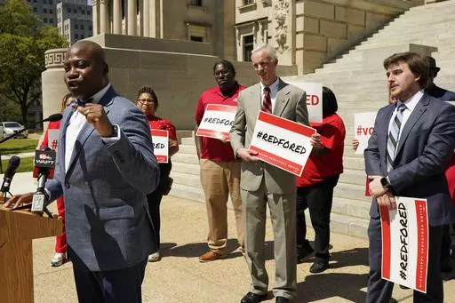 Sen. Derrick Simmons, D-Greenville, left, acknowledges the efforts of Senate Education Committee Vice Chairman David Blount, D-Jackson, center, and House Education Committee Vice Chairman Kent McCarty, R-Hattiesburg, to support public school education, but called for the continued efforts of educators, parents and business leaders to encourage lawmakers to secure yearly full funding for the public schools, Thursday, March 23, 2023, at a Mississippi Association of Educators news conference at the