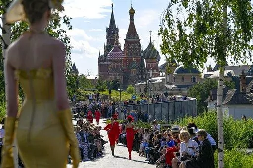 A model displays the collection by Russian designer Slava Zaitsev during the opening of the Fashion Week in at Zaryadye Park with the Spasskaya Tower and St. Basil's Cathedral in the background near Red Square in Moscow, Russia, on June 20, 2022. Luxury spending is growing faster than ever, fueled by pent-up pandemic demand and shifting demographics as younger, more diverse consumers buy into tiny handbag and post-streetwear trends, according to a new study by Bain consultancy released on Tuesda
