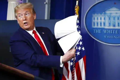 President Donald Trump holds up papers as he speaks about the coronavirus in the James Brady Press Briefing Room of the White House, April 20, 2020, in Washington. As president, Donald Trump never liked to leave a paper trail. He avoided email, admonished aides to stop taking notes during meetings and ripped up documents when he finished with them.  But Trump was unwilling to part with some of his administration's records when he left the White House last year, whisking them away to Mar-a-Lago, 