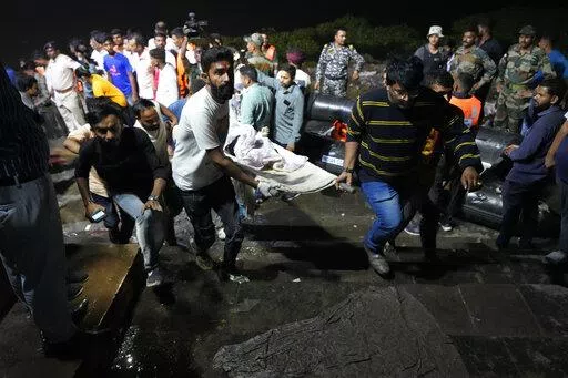 Volunteers carry a victim after a cable bridge across the Machchu river collapsed in Morbi town of western state Gujarat, India, Monday, Oct. 31, 2022. More than 400 people died in October in a series of crowd-related disasters in Asia that could have been prevented if authorities had acted differently. (AP Photo/Ajit Solanki, File)