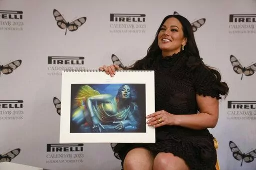 Model Ashley Graham holds her picture on the Pirelli calendar as she discusses her appearance in the 2023 Pirelli calendar during a press preview at the 15th Century Bicocca degli Arcimboldi Villa at Pirelli's headquarters in Milan, Italy, Tuesday, Nov. 15, 2022. The 2023 calendar titled "Love Letters to the Muse" was shot by Australia photographer Emma Summerton and features models representing their personal passions. (AP Photo/Luca Bruno)