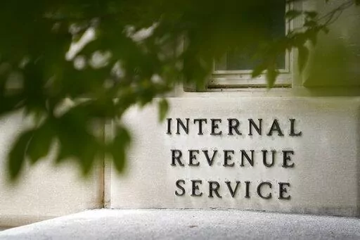 A sign is displayed outside the Internal Revenue Service building May 4, 2021, in Washington.  On Friday, Aug. 19, 2022, The Associated Press reported on stories circulating online incorrectly claiming an online job ad shows that all new employees that the IRS intends to hire after a funding boost in the Inflation Reduction Act will be required to carry a firearm and use deadly force if necessary.  (AP Photo/Patrick Semansky, File)