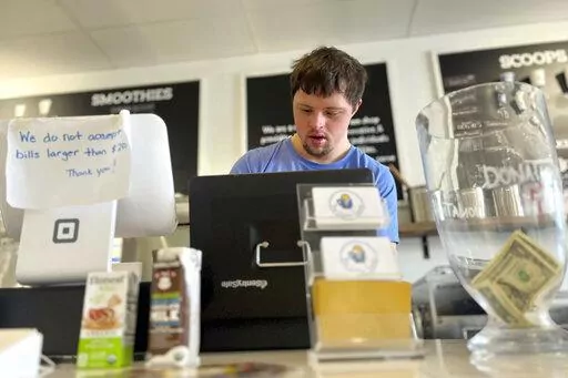 Patrick Chapman, 27, prepares for customers Thursday, March 2, 2023, at The Golden Scoop, an Overland Park, Kan., ice cream and coffee shop that employs workers with developmental disabilities, paying them more than minimum wage. But some disabled workers employed at so-called sheltered workshops are earning far less than minimum wage, an issue that has captured the attention of lawmakers in the state. Disability rights advocates say the practice is discriminatory and more than a dozen states ha