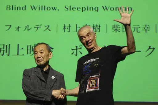 Novelist Haruki Murakami and film director Pierre Foldes shake hands at the end of a talk session after a screening of “Blind Willow, Sleeping Woman,” an animated film adapted from the Japanese author’s short stories, in Tokyo, June 15, 2024. (AP Photo/Mari Yamaguchi)