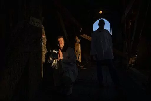 Retired policeman, Volodymyr Ilnytskyi, 55, prays before ringing the bell of the Latin Cathedral in Lviv, western Ukraine, Thursday, March 24, 2022. (AP Photo/Nariman El-Mofty)