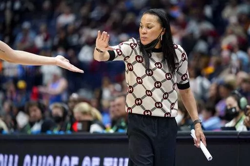 South Carolina head coach Dawn Staley congratulates a player during the second half of an NCAA college basketball semifinal round game against Mississippi at the women's Southeastern Conference tournament Saturday, March 5, 2022, in Nashville, Tenn. South Carolina won 61-51. (AP Photo/Mark Humphrey)