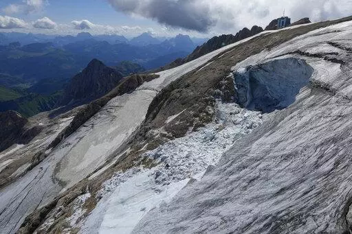 A view taken from a rescue helicopter of the Punta Rocca glacier near Canazei, in the Italian Alps in northern Italy, Tuesday, July 5, 2022, two days after a huge chunk of the glacier broke loose, sending an avalanche of ice, snow, and rocks onto hikers. Italy was enduring a prolonged heat wave before a massive piece of the Alpine glacier broke off and killed hikers on Sunday and experts say climate change will make those hot, destabilizing conditions more common. (AP Photo/Luca Bruno)