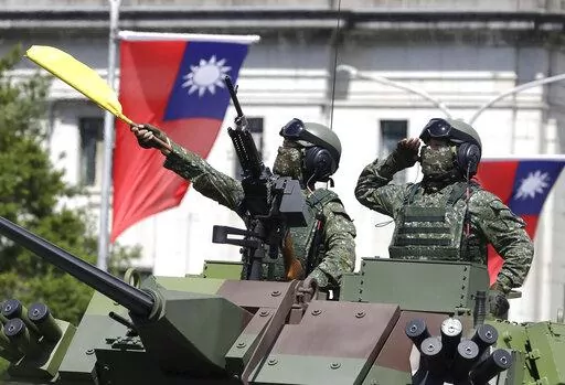 Taiwanese soldiers salute during National Day celebrations in front of the Presidential Building in Taipei, Taiwan on Oct. 10, 2021. As Russia presses ahead with its attack on Ukraine, many analysts and internet users have drawn comparisons to Taiwan, another place that could face an invasion by its larger neighbor, in this case China. (AP Photo/Chiang Ying-ying, File)