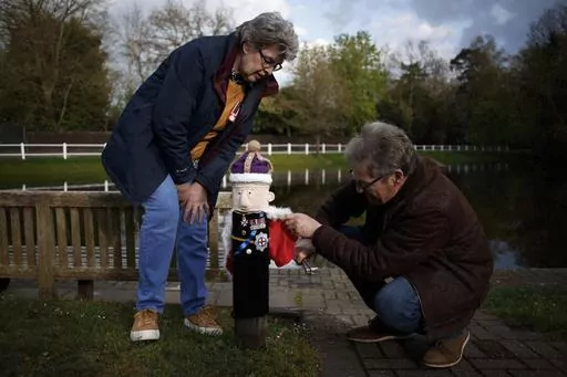 Heather and David Howarth adjust a knitted figure of Britain's King Charles III fitted to a post during a pre-coronation 'yarn bombing' in the village of Hurst, near Reading, England, Friday, April 21, 2023. Howarth and her friends in the village of Hurst, a stone’s throw from Reading, west of London, have fashioned a woolly coronation procession to rival the pomp and circumstance that will take place when Charles is crowned on May 6 at Westminster Abbey. (AP Photo/David Cliff)