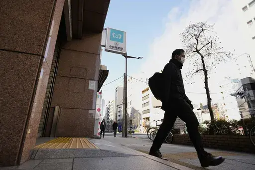 A subway sign, center top, is seen at the Kodenmacho station, that was affected by a deadly sarin nerve gas attack 30 years ago, in Tokyo, as a passenger gets out of its exit Thursday, March 20, 2025. (AP Photo/Hiro Komae)