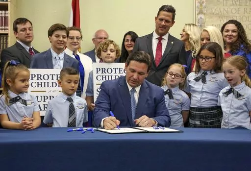 Florida Gov. Ron DeSantis signs the Parental Rights in Education bill, also known as the "Don't Say Gay" bill, at Classical Preparatory School, March 28, 2022, in Shady Hills, Fla. Students and teachers will be able to speak freely about sexual orientation and gender identity in Florida classrooms, provided it’s not part of instruction, under a settlement reached Monday, March 11, 2024, between Florida education officials and civil rights attorneys who had challenged a state law which critics 