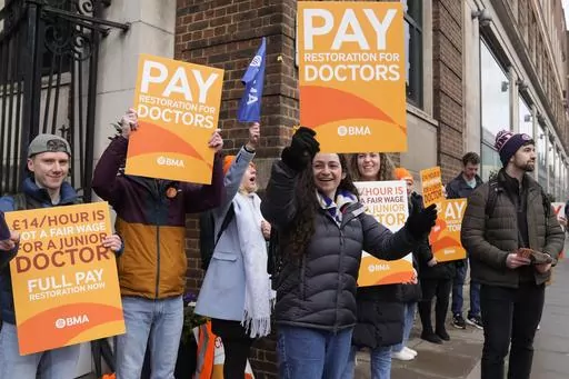 Junior doctors hold placards on a picket line outside St Mary's Hospital in London, Tuesday, March 14, 2023. Unions representing hundreds of thousands of nurses, ambulance crews and other health care workers in England reached a deal Thursday, March 16, 2023, to resolve months of disruptive strikes for higher wages, though the pact didn't include doctors. (AP Photo/Alastair Grant, File)