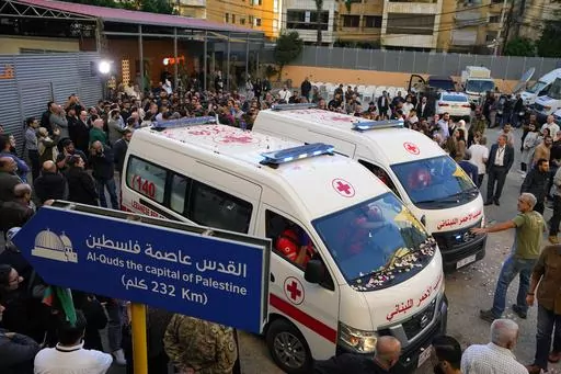 Journalists and family members gather next to Lebanese Red Cross ambulances carrying the bodies of the two slain journalists of pan-Arab TV network Al-Mayadeenm, who were killed by an Israeli strike outside the station's headquarters in Beirut, Lebanon, Tuesday, Nov. 21, 2023. An Israeli strike on southern Lebanon killed Tuesday two journalists reporting for the Beirut-based Al-Mayadeen TV on the violence along the border with Israel, according to the Lebanese information minister and their TV s