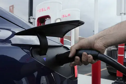 A motorist charges his electric vehicle at a Tesla Supercharger station in Detroit, Nov. 16, 2022. (AP Photo/Paul Sancya, File)