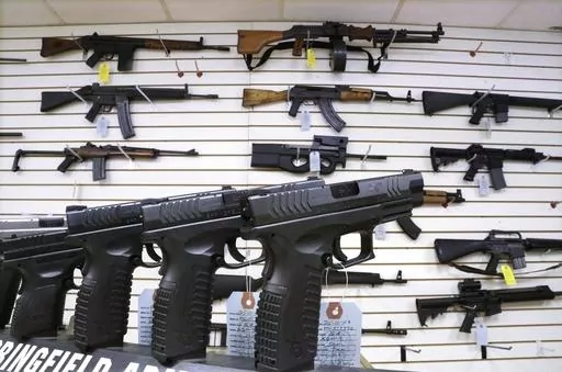 Semi-automatic guns are displayed for sale at Capitol City Arms Supply, Jan. 16, 2013, in Springfield, Ill. Illinois will soon outlaw advertising for firearms that officials determine produces a public safety threat or appeals to children, militants or others who might later use them illegally, as the state continues its quest to curb mass shootings. (AP Photo/Seth Perlman, File)