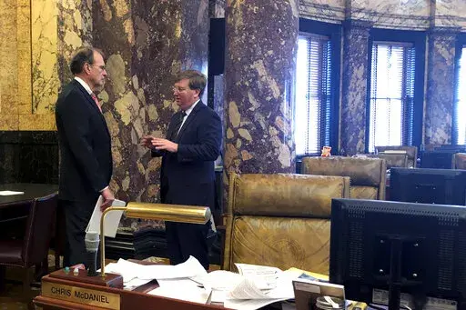 Lt. Gov. Delbert Hosemann, left, and Gov. Tate Reeves confer in an empty Senate chamber at the Mississippi State Capitol in Jackson, Miss., Tuesday, Feb. 1, 2022. (AP Photo/Emily Wagster Pettus)