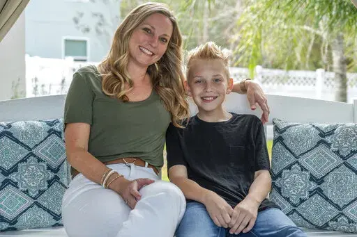 Holly Nover sits with her son, Colton Nover, 10, on a backyard swing at their home Wednesday, Feb. 16, 2022, in St. Johns, Fla. Holly, a speech pathologist active in the National Stuttering Association, said many people will surely be interested in trying stuttering medications – although not her. She is happy with her life as it is and has accepted her stuttering, she said. If her son were struggling and wanted to try medication as a teen, however, she’d be open to the idea. (AP Photo/Fran 