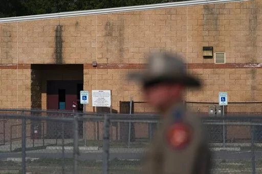 A back door at Robb Elementary School, where a gunman entered through to get into a classroom in last week's shooting, is seen in the distance in Uvalde, Texas, Monday, May 30, 2022. (AP Photo/Jae C. Hong)