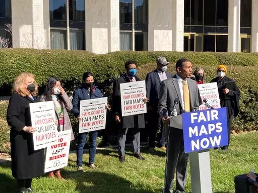 Reggie Weaver, at podium, speaks outside the Legislative Building in Raleigh, N.C., Feb. 15, 2022, about a partisan gerrymandering ruling by the North Carolina Supreme Court. The Supreme Court has ruled that North Carolina’s top court did not overstep its bounds in striking down a congressional districting plan as excessively partisan under state law. The justices on Tuesday rejected the broadest view of a case that could have transformed elections for Congress and president by leaving state l