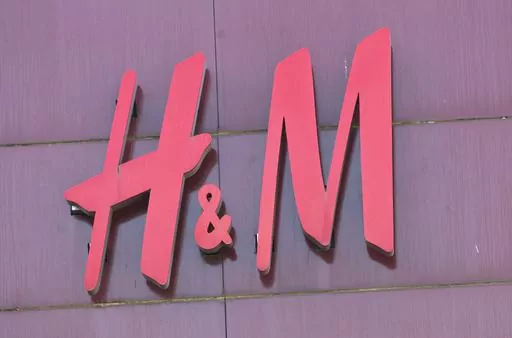 The logo of Swedish clothing-retail company Hennes & Mauritz (H&M) is pictured in Velizy, outside Paris, France, Wednesday, Sept. 20, 2017. A pioneering bill to curb the rampant pace of fast fashion won unanimous approval in the French Parliament, making France one of the first countries in the world to target the influx of low-cost, mass-produced garments. (AP Photo/Michel Euler)