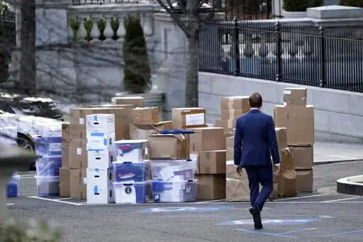 A man walks past boxes that were moved out of the Eisenhower Executive Office building, just outside the West Wing, inside the White House complex, Thursday, Jan. 14, 2021, in Washington. The State Department says it's unable to compile a complete accounting of gifts presented to U.S. officials by foreign governments during the final year of the Trump administration due to missing White House data.  (AP Photo/Gerald Herbert, File)