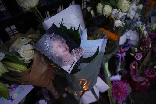 Messages, flowers and candles are seen at the gates of Buckingham Palace in London, Friday, Sept. 9, 2022. (AP Photo/Kirsty Wigglesworth)