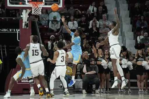 Southern University guard Brandon Davis, second from right, makes a banked shot to score in the final seconds against Mississippi State during the second half of an NCAA college basketball game, Sunday, Dec. 3, 2023, in Starkville, Miss. (AP Photo/Rogelio V. Solis)