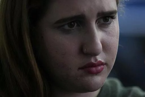 Eden Hebron, 19, talks about the years of work she has done to cope with trauma and mental health effects after witnessing a gunman kill a close friend and two other students in Florida's 2018 high school massacre in Parkland, during an interview with Associated Press journalists, Tuesday, March 8, 2022, in Hollywood, Fla. Hebron's experience shows how many of the survivors have grappled with severe mental health issues that derailed their adolescence and greatly impacted their families.(AP Phot