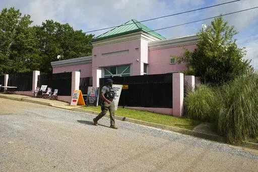 A security officer walks past the front of the Jackson Women's Health Organization clinic in Jackson, Miss., Sunday, July 3, 2022. The medical facility was open for three hours before anti-abortion protesters arrived. The clinic is the only facility that performs abortions in the state. On June 24, the U.S. Supreme Court overturned Roe v. Wade, ending constitutional protections for abortion. However, a Mississippi judge has set a hearing for Tuesday, in a lawsuit by the state's only abortion cli
