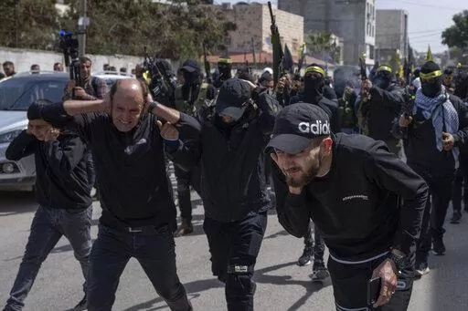Palestinian gunmen shoot in the air during the funerals for Sanad Abu Atiyeh, 17 and Yazid al-Saadi, 23, in the West Bank refugee camp of Jenin, Jenin, Thursday, March 31, 2022. Israeli forces raided a refugee camp in the occupied West Bank early Thursday, setting off a gun battle in which two Palestinians were killed and 15 were wounded, the Palestinian Health Ministry said. (AP Photo/Nasser Nasser)