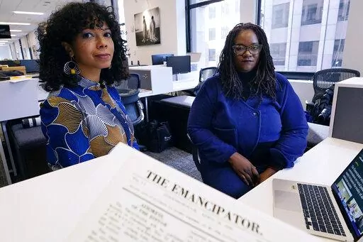 Amber Payne, left, and Deborah Douglas co-editors-in-chief of the new online publication of "The Emancipator" pose at their office inside the Boston Globe, Wednesday, Feb. 2, 2022, in Boston. Boston University's Center for Antiracist Research and The Boston Globe's Opinion team are collaborating to resurrect and reimagine The Emancipator, the first abolitionist newspaper in the United States, which was founded more than 200 years ago. The new incarnation of The Emancipator will explore ways to r