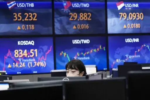 A currency trader watches monitors at the foreign exchange dealing room of the KEB Hana Bank headquarters in Seoul, South Korea, Thursday, Aug. 11, 2022. Shares advanced Thursday in Asia after benchmarks closed at three-month highs on Wall Street as investors cheered a report showing inflation cooled more than expected in July. (AP Photo/Ahn Young-joon)