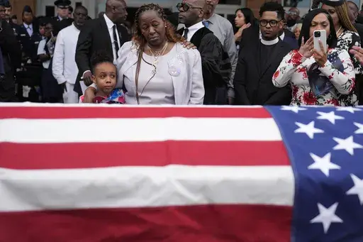 Chantemekki Fortson the mother of slain airman Roger Fortson, right, along with family watch Fortson's casket as they leave for a cemetery during his funeral at New Birth Missionary Baptist Church, on May 17, 2024, in Stonecrest, Ga. (AP Photo/Brynn Anderson, File)