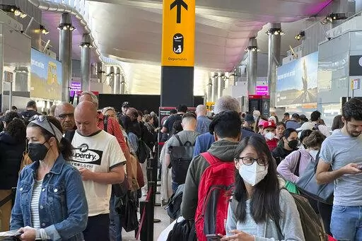 Travellers queue at security at Heathrow Airport in London, Wednesday, June 22, 2022. London’s Heathrow Airport  apologized Monday, July 11, 2022 to passengers whose travels have been disrupted by staff shortages. The airport warned that it may ask airlines to cut more flights from their summer schedules to reduce the strain if the chaos persists. (AP Photo/Frank Augstein, File)