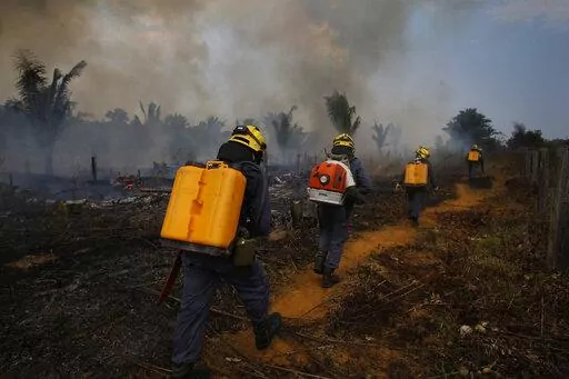 Fire brigade members walk in to a burnt area in Apui, Amazonas state, Brazil, Sept. 21, 2022. Despite the smoke clogging the air of entire Amazon cities, state elections have largely ignored environmental issues. Far-right President Jair Bolsonaro is seeking a second four-year term against leftist Luiz Inácio Lula da Silva, who ruled Brazil between 2003 and 2010. (AP Photo/Edmar Barros, File)