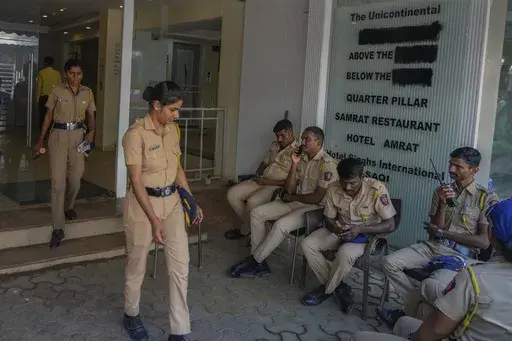 Police officers gather outside the building of the studio where Indian comedian Kunal Kamra allegedly made "defamatory" remarks against Shiv Sena politician Eknath Shinde and was ransacked by Shiv Sena party workers, in Mumbai, India, Monday, March 24, 2025. (AP Photo/Rafiq Maqbool)