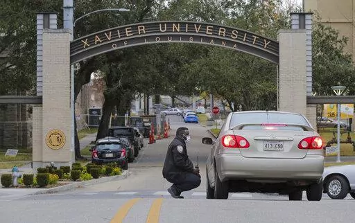 A Xavier University police officer redirects a motorist around campus after a bomb threat put the campus on lockdown in New Orleans, La., Feb. 1, 2022. As the nation’s historically Black colleges remain on edge after receiving dozens of bomb threats in recent weeks, federal law enforcement officials said they have identified six suspects who they believe are responsible for most of the racially motivated crimes. (David Grunfeld/The Advocate via AP, File)