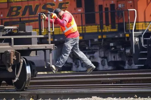 A worker rides a rail car at a BNSF rail crossing in Saginaw, Texas, Wednesday, Sept. 14, 2022. Business and government officials are preparing for a potential nationwide rail strike at the end of this week while talks carry on between the largest U.S. freight railroads and their unions. (AP Photo/LM Otero)