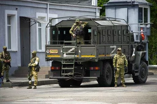 Russian soldiers guard an area as a group of foreign journalists visit in Kherson, Kherson region, south Ukraine, May 20, 2022. The southern city of Kherson was the first to fall to Russia's invasion. But Kherson remains at the heart of the conflict and Ukraine's efforts to save its vital access to the sea. (AP Photo, File)