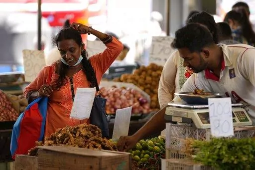 A woman bargains as she buys vegetables at a market place in Colombo, Sri Lanka, Friday, June 10, 2022. The International Monetary Fund said Thursday, Sept. 1, 2022, it has reached a staff-level agreement with Sri Lanka to provide $ 2.9 billion over four years to help salvage the country from its worst economic crisis in recent memory. (AP Photo/Eranga Jayawardena, File)