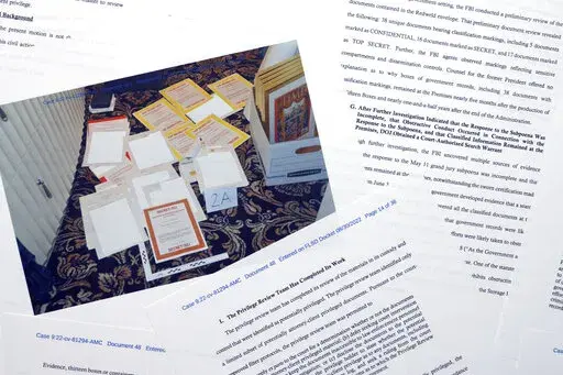 Pages from a Department of Justice court filing on Aug. 30, 2022, in response to a request from the legal team of former President Donald Trump for a special master to review the documents seized during the Aug. 8 search of Mar-a-Lago, are photographed early Wednesday, Aug. 31, 2022. Included in the filing was a FBI photo of documents that were seized during the search. (AP Photo/Jon Elswick)