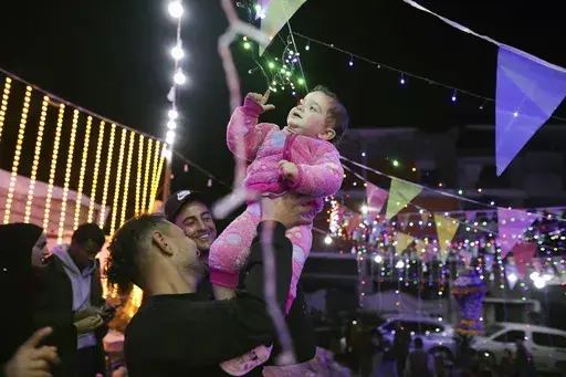 Festive lights are strung between destroyed Palestinian homes for the holy month of Ramadan in Khan Younis, southern Gaza Strip, Friday, Feb. 28, 2025. (AP Photo/Jehad Alshrafi)