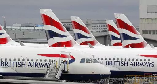British Airways planes parked at Heathrow Airport's Terminal 5 in London, Wednesday, March 18, 2020. Mixed signals are emerging about travel in Europe heading into the winter season. British Airways is cutting more than 10,000 short-haul flights in and out of Heathrow Airport through March 2023, while nearby Gatwick Airport is ending its limits on the number of daily flights. (AP Photo/Frank Augstein, File)