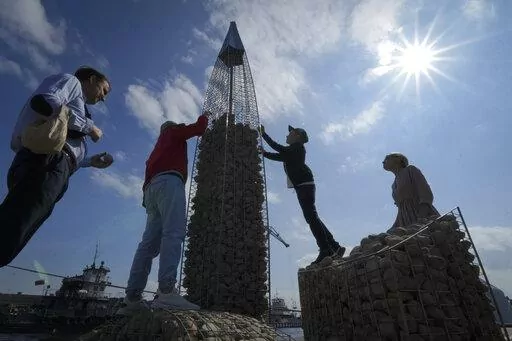 People build a model of the business tower Lakhta Centre, at the headquarters of Russian gas monopoly Gazprom, filling the frame with stones, in St. Petersburg, Russia, Thursday, June 9, 2022. It's not a summer heat wave that's making European leaders and businesses sweat. It's fear that Russia's manipulation of natural gas supplies will lead to an economic and political crisis next winter. Or, in the worst case, even sooner. (AP Photo/Dmitri Lovetsky, File)