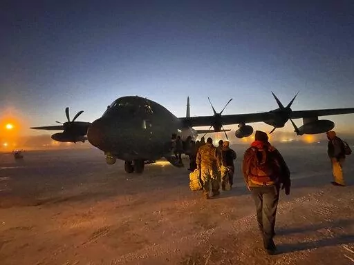 Helpers in the Alaska National Guard's Operation Santa Claus board a cargo plane at Joint Base Elmendorf-Anchorage on Tuesday, Nov. 29, 2022, for a flight to Nuiqsut, Alaska. The guard's outreach program attempts to bring Santa and Mrs. Claus and gifts to children in two or three Alaska Native villages each year. (AP Photo/Mark Thiessen)
