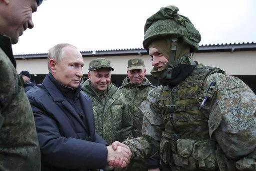 Russian President Vladimir Putin shakes hands with a soldier as he visits a military training centre of the Western Military District for mobilised reservists as Russian Defense Minister Sergei Shoigu, center, smiles in Ryazan Region, Russia, Thursday, Oct. 20, 2022. The mobilized reservists that Russian President Vladimir Putin visited last week at a firing range southeast of Moscow looked picture-perfect. (Mikhail Klimentyev, Sputnik, Kremlin Pool Photo via AP, File)