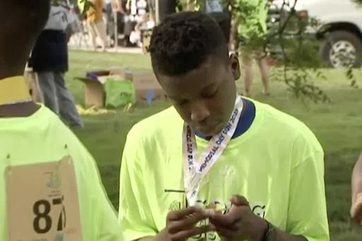 Ralph Yarl looks at a badge that he received after walking at a brain injury awareness event, May 29, 2023, in Kansas City, Mo. The family of Yarl, a Black teenager who was shot when he mistakenly went to the wrong home in Kansas City, Mo., filed a lawsuit Monday, April 29, 2024, against the white 84-year-old homeowner, an attempt to pursue justice from the “driver’s seat” and put pressure on the criminal trial scheduled for later this year, the family's attorney said. (KCTV via AP, File)