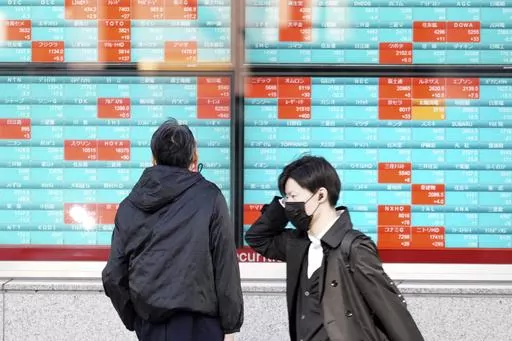 A person looks at an electronic stock board showing Japan's Nikkei 225 index at a securities firm Wednesday, Nov. 29, 2023, in Tokyo. Asian markets were steady in holiday-thinned trading on Tuesday, Dec. 26, 2023, with some markets in the region closed for holidays.(AP Photo/Eugene Hoshiko)