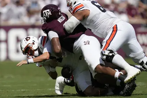 Auburn quarterback Payton Thorne, left, is sacked by then-Texas A&M defensive lineman Walter Nolen, right, and linebacker Chris Russell Jr., bottom, during the first half of an NCAA college football game Saturday, Sept. 23, 2023, in College Station, Texas. (AP Photo/Sam Craft, File)