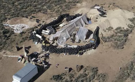 A ramshackle compound is seen in the desert area of Amalia, N.M., on Aug. 10, 2018. Two firearms charges were dismissed Thursday, Sept. 21, 2023, amid preparations for trial against an extended family arrested in a 2018 law enforcement raid on the compound in northern New Mexico and the discovery of a young boy's decomposed body. (AP Photo/Brian Skoloff, File)